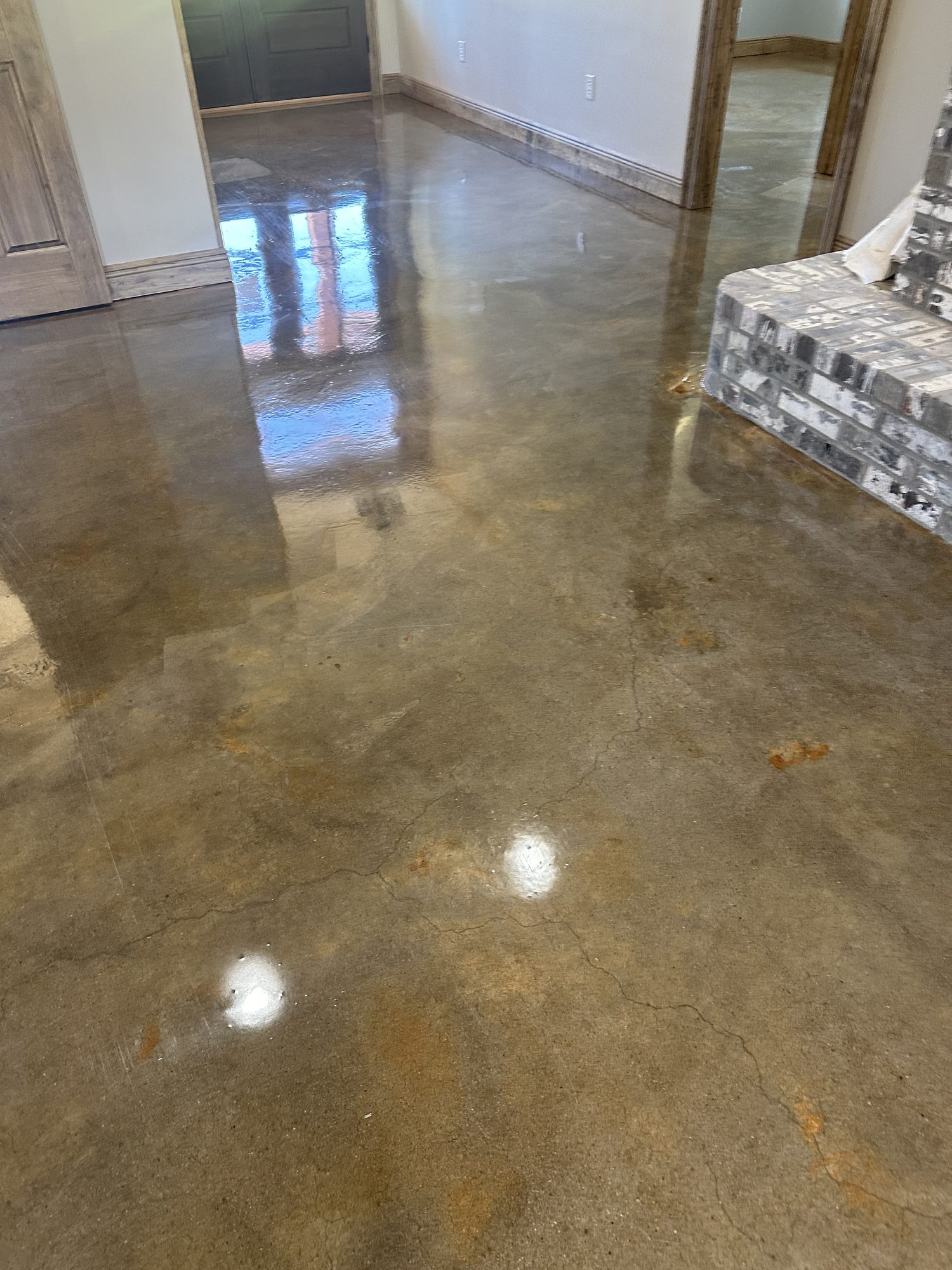Stained and polished concrete floor in a tan mottled finish reflecting a doorway, Huntsville, AL