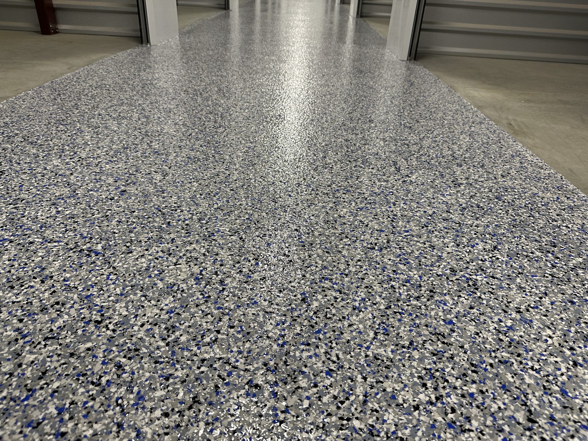 Gray and blue flake epoxy floor running between roll up storage unit doors, Huntsville, AL