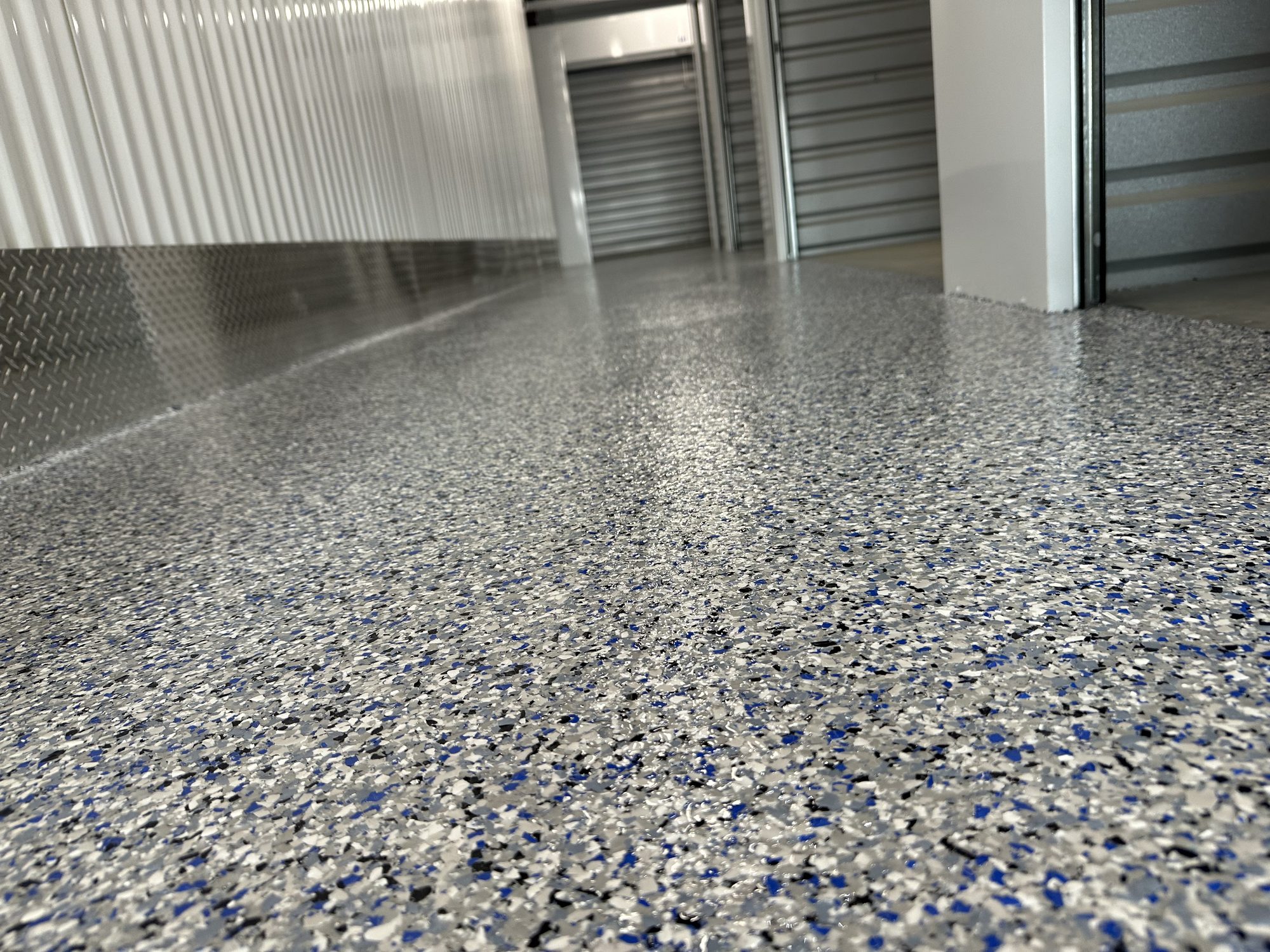 Flake epoxy floor in a storage facility corridor with corrugated unit doors, Huntsville, AL