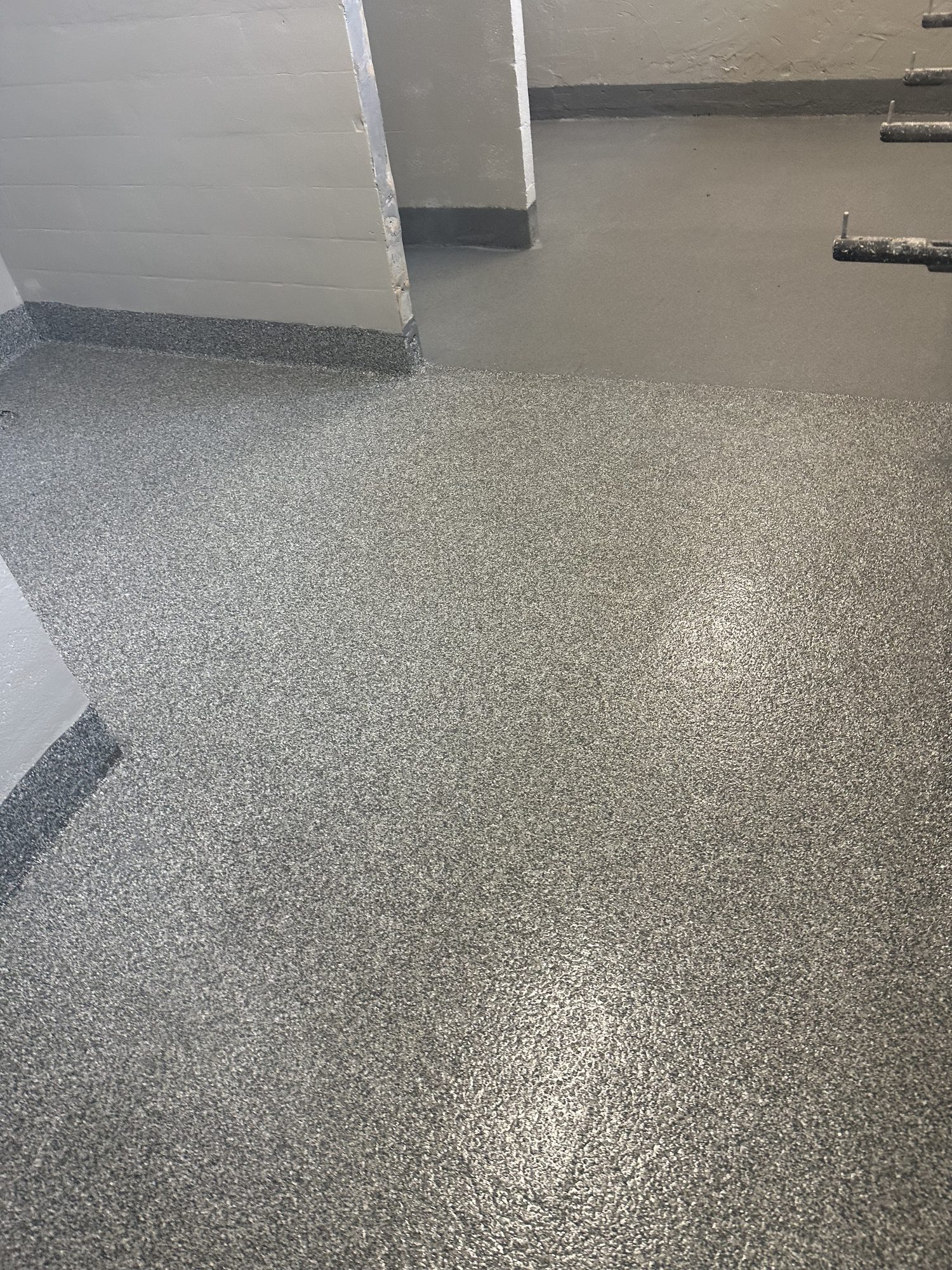 Gray flake epoxy floor with coved edges in a commercial washroom area, Huntsville, AL