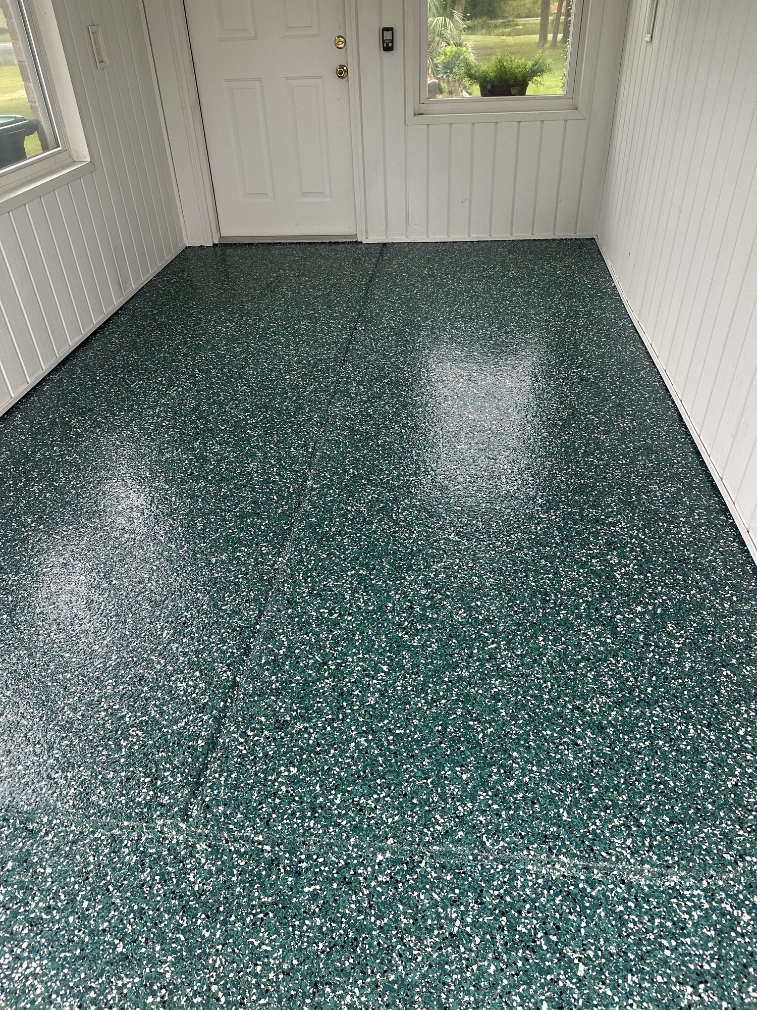 Dark green and white flake epoxy porch floor with a white door and panelled wall, Huntsville, AL
